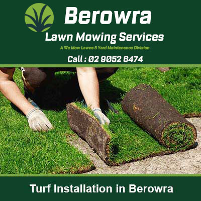 Hands in gloves placing rolls of fresh turf in Berowra